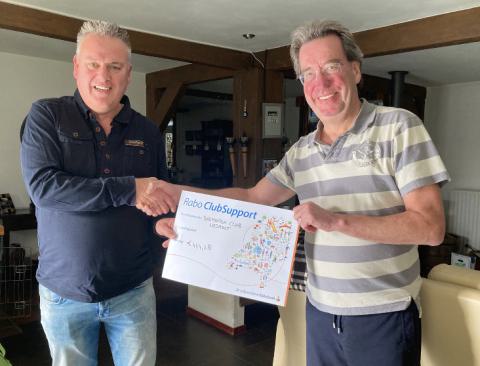 Frank van Elderen (r.) overhandigd namens de Rabobank de waardecheque aan Stan van Vijfeijken van Badminton Club Lieshout.